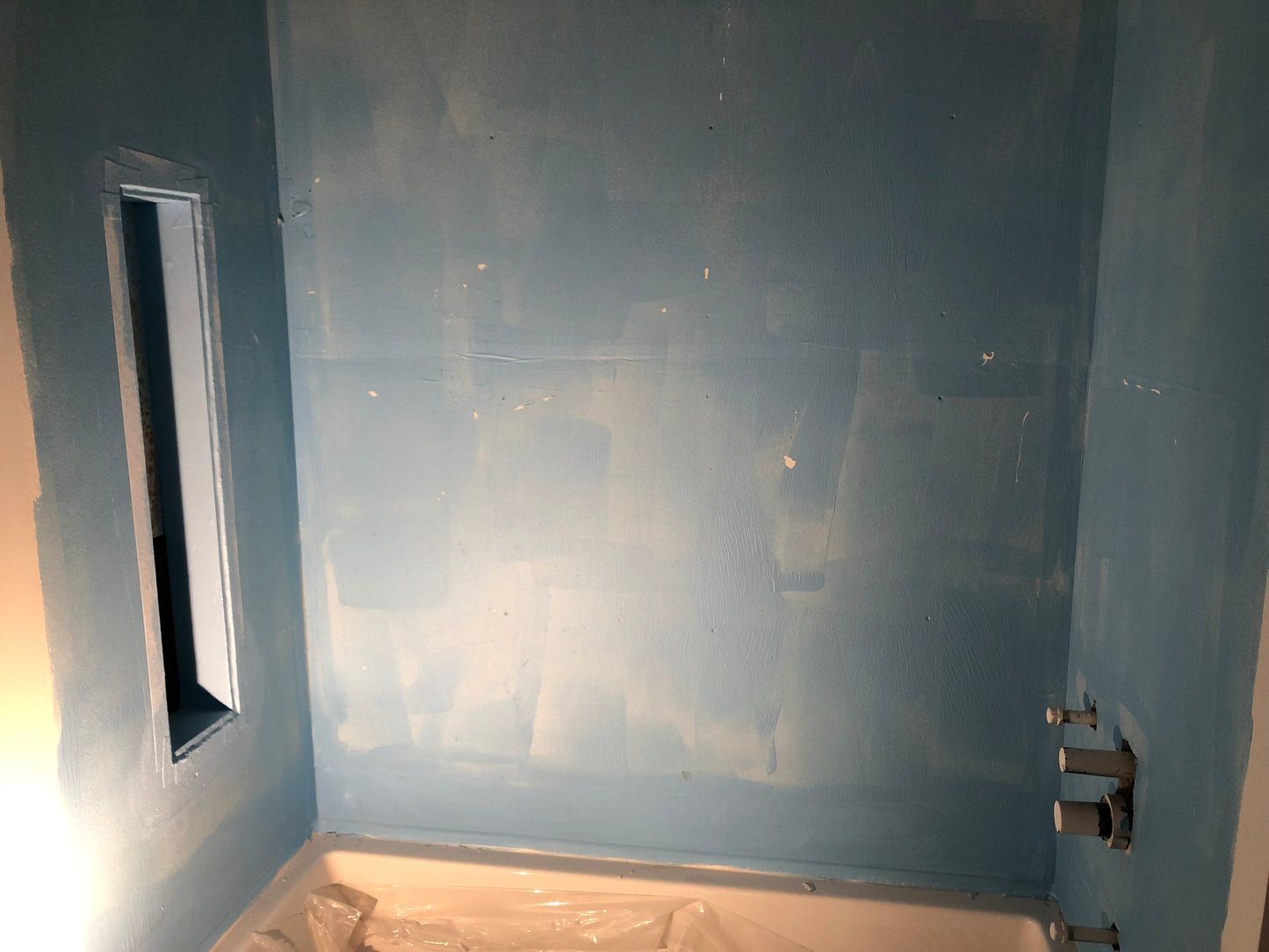 Première application de la membrane bleu sur les mur du bain/douche